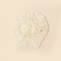 Close-up of beige lace baby turban hat with delicate floral crochet and bow detail - 20*17cm / Beige