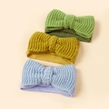 Detail of three knitted baby headbands in green, yellow, and purple with large bows - Random Color