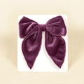 Close-up of dark purple velvet bow hair clip with fine stitching on white card - 13cmx12.5cm / Purple