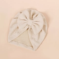 Detailed texture of beige waffle fabric baby turban hat featuring a large soft bow accent - 17*18.5cm / Beige