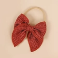 Close-up of a red textured fabric bow on a soft nude elastic nylon baby headband - 10.5*10.5cm / Red