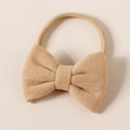 Close-up of a soft beige cashmere-like bow baby headband with stretchy nylon band - 8.5*6cm / Nude