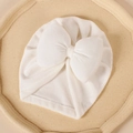 Gros plan sur le bonnet bébé blanc en tricot côtelé avec un grand nœud décoratif - 17.5*8.3cm / Blanc