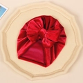 Detail of red baby velvet turban hat with oversized bow on a minimalist stone tray - Red