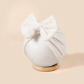 Primer plano del gorro turbante para bebé en punto blanco con un lazo grande - 18*18cm / Blanco