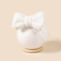 Vue détaillée d'un bandeau blanc à gros nœud en jacquard pour bébé sur support rond - 16*8.5cm / Blanc