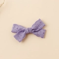 Dettaglio del fermaglio a farfalla in pizzo viola ricamato con motivi floreali - 8.5x5cm / Viola