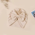 Detail of baby turban hat with ribbed knit texture and a large cream beige bow tie - 17.5x17 cm / Off White (#6)
