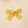 Detail of yellow lace embroidered bow hair clip with intricate floral patterns - 8.5x6cm / Yellow