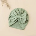 Detail shot of a sage green ribbed knit baby turban hat with a large decorative bow - 17.5x17 cm / Green (#7)