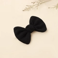 Detalle de horquilla con lazo de punto negro sobre un fondo beige de estilo minimalista - Negro