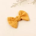 Detail of yellow cotton linen bow hair clip with textured fabric and dried flower accents - Earthy Yellow