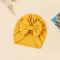Close-up of mustard yellow baby beanie with ribbed knit texture and oversized bow detail - 17.5x17 cm / Turmeric