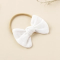 Primer plano de una diadema para bebé con lazo de algodón blanco y banda elástica de nailon - Blanco