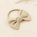 Primer plano de una diadema beige para bebé con lazo de algodón y banda elástica - Beige