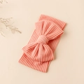 Nahaufnahme des rosa gerippten Baby-Stirnbandes mit Schleife und Wellenstruktur - Hellorange