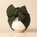 Détails de la texture du bonnet bébé vert olive en maille gaufrée avec un grand nœud doux - vert foncé