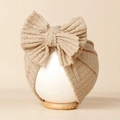 Gros plan d'un bonnet pour bébé en maille gaufrée avec un grand nœud décoratif - 20*18cm / Kaki