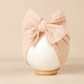 Texture détaillée d'un bonnet gaufré pour bébé avec un grand nœud décoratif rose doux - 20*18cm / Rose Corail