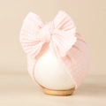 Détail du bonnet pour bébé en maille gaufrée rose clair avec un grand nœud décoratif - 20*18cm / Rose Clair