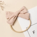 Vue détaillée du nœud en velours côtelé rose avec paillettes dorées sur bandeau bébé - 9.5*6cm / Rose
