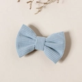 Gros plan détaillé d'une barrette à cheveux nœud bleu clair avec texture nid d'abeille - 8.5x5.5cm / Bleu lac