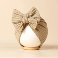 Détail du tricot gaufré kaki et du grand nœud sur ce bonnet turban pour bébé - 20*18cm / Nu