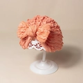 Dettaglio di un turbante per neonati rosa pesca con fiocco su un supporto traforato - 17.5x15.5cm / Rosso anguria