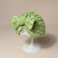 Dettaglio di un turbante per neonati verde chiaro con fiocco grande e trama a balze - 17.5x15.5cm / Verde