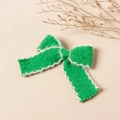 Dettaglio del fermaglio per capelli a fiocco in maglia verde con bordo in finta pelliccia - Verde