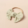 Nahaufnahme eines cremefarbenen Baby-Stirnbands mit weicher Strickschleife und Zopfmuster - Altweiß (#13)