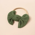 Detailansicht einer grünen Jacquard-Schleife auf einem elastischen Baby-Stirnband - Grasgrün (#10)