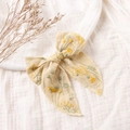 Dettaglio della fascia in cotone crema con ricami floreali gialli ed elastico morbido - 10,5*12cm / Beige