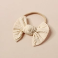 Nahaufnahme des cremeweißen Strick-Stirnbands für Babys mit weichem Zopfmuster und Schleife - Cremeweiß (#9)