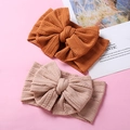 Vue détaillée de deux bandeaux bébé en maille souple avec grands nœuds en caramel et rose - 15*9cm / Couleur Aléatoire