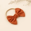 Elastic nylon headband for babies featuring a textured burnt orange candy style bow - Orange Red