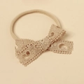 Dettaglio fascia per neonati in pizzo con fiocco in nylon beige stile vintage - Cachi