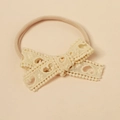 Detail of baby headband featuring lace bow with hollow heart pattern and nylon band - Light Yellow