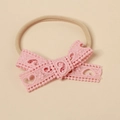 Detail view of pink lace bow with heart patterns on soft nylon baby headband - Pink