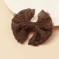 Dettaglio del fermaglio per capelli in pizzo marrone scuro con fiocco a strati vintage - caffè