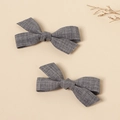 Detail of two grey handmade linen bow hair clips on a minimalist beige background - Dark Gray