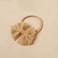 Detail eines Baby-Spitzenstirnbandes in Apricot mit elastischem Nylon und Netzstruktur - Einheitsgröße / Hellbraun