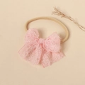 Dettaglio del fiocco in pizzo rosa su fascia elastica in nylon per neonati e bimbe - Rosa