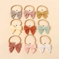 Détail de 9 bandeaux bébé en nylon avec nœuds brodés ajourés aux couleurs douces - Couleur Aléatoire