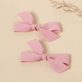 Close-up of pink fabric bow hair clips with textured linen material and handmade knots - Pink