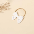 Close-up of baby lace bow headband with delicate floral embroidery on nylon band - White