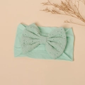 Detail view of mint green baby headband featuring eyelet embroidery and a large bow - Lake Green