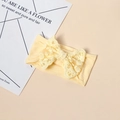 Detail eines Baby Stirnbandes aus weichem Strick mit feiner floraler Spitzen Schleife - Gelb