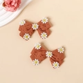 Détail macro de barrettes à nœuds en coton marron avec broderie de marguerites blanches - Rouge Orangé