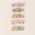 Close-up of five colorful candy-shaped fabric hair clips for kids in macalon plaid patterns - Random Color